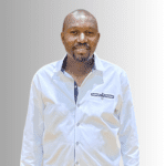 Smiling man in a white button-up shirt.