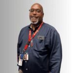 Smiling man in a blue shirt with lanyard.