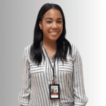 Smiling woman in striped shirt and lanyard.