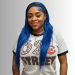 Smiling woman with blue hair and t-shirt.